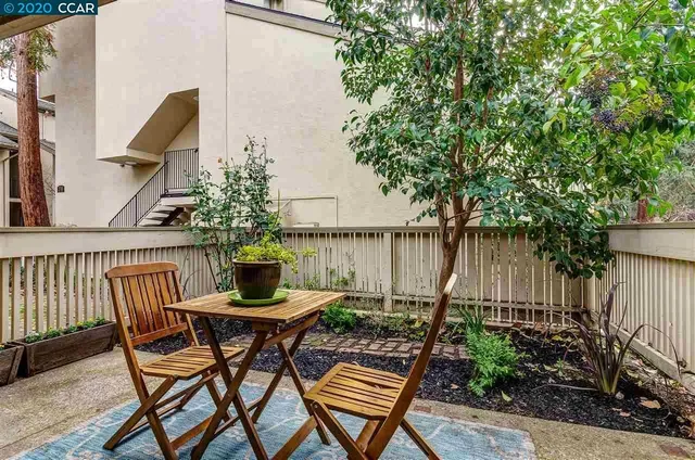 a view of a chairs and table in the back yard of a house