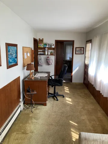 a view of a workspace with furniture and a window