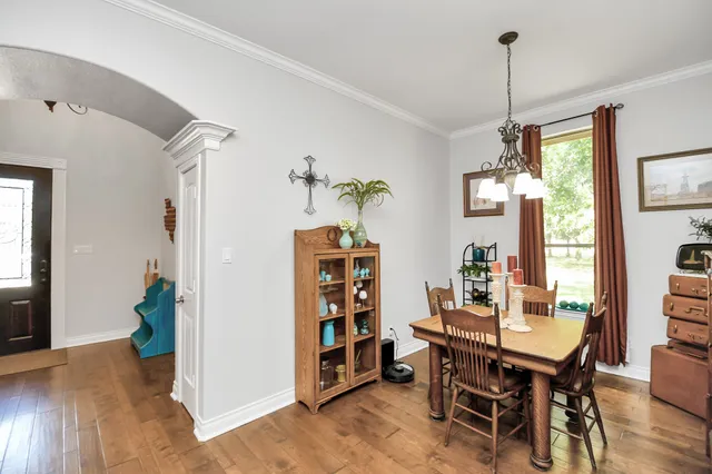 a kitchen with a stove a sink dishwasher a dining table and chairs with wooden floor