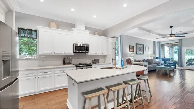 a kitchen with stainless steel appliances granite countertop a table chairs refrigerator and sink