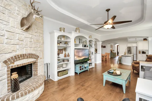 a view of a kitchen with a sink and a stove with a bookshelf