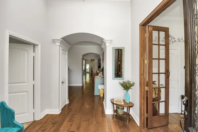 a view of a hallway with wooden floor and furniture