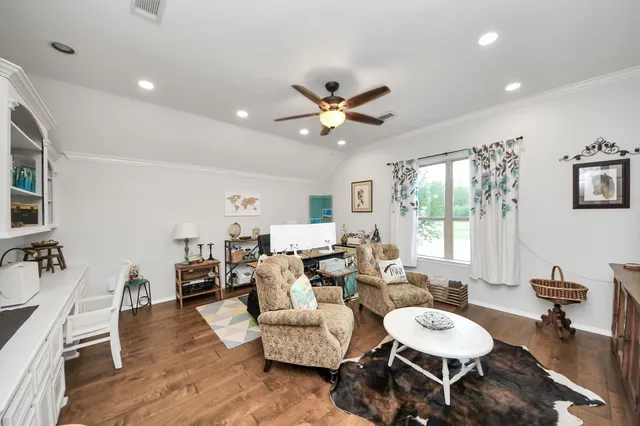 a living room with furniture kitchen view and a wooden floor