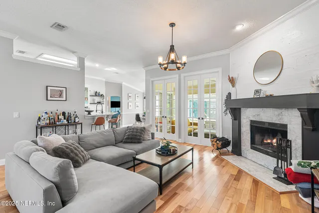 a living room with furniture a fireplace and a chandelier