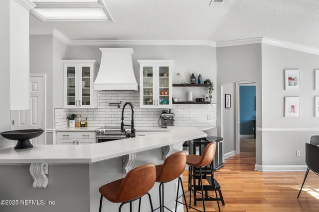 a kitchen with stainless steel appliances a sink a stove a table and chairs