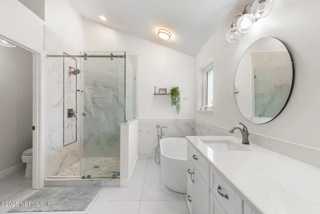 a bathroom with a granite countertop sink a mirror and a shower