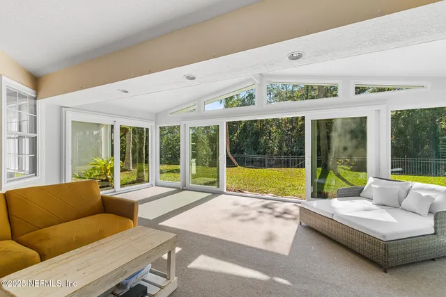 a living room with furniture and large windows