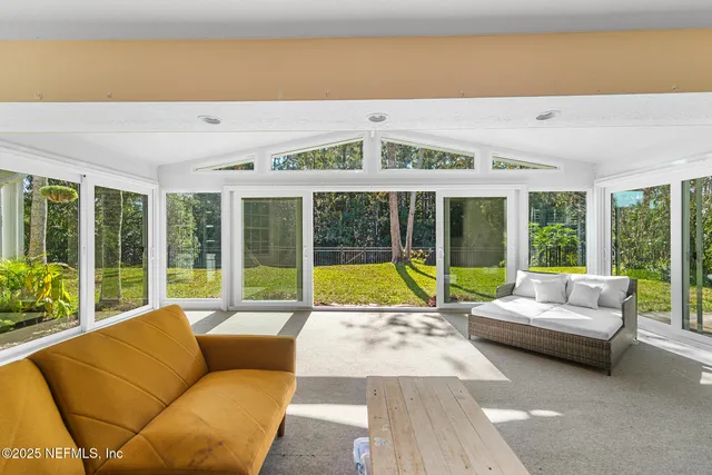 a living room with furniture and floor to ceiling windows