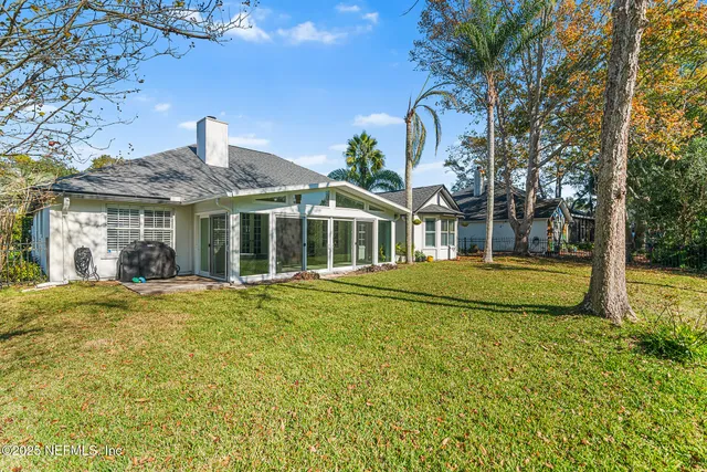 a view of a house with a big yard and large trees