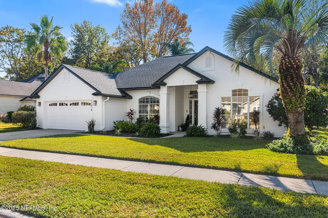 a front view of a house with a yard and trees
