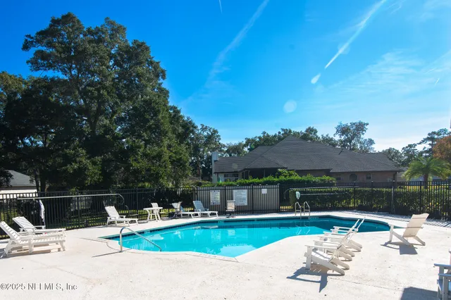 a view of backyard with swimming pool and seating space