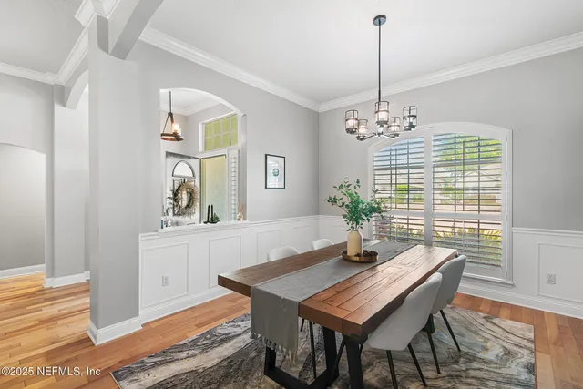 a dining room with furniture a chandelier and wooden floor