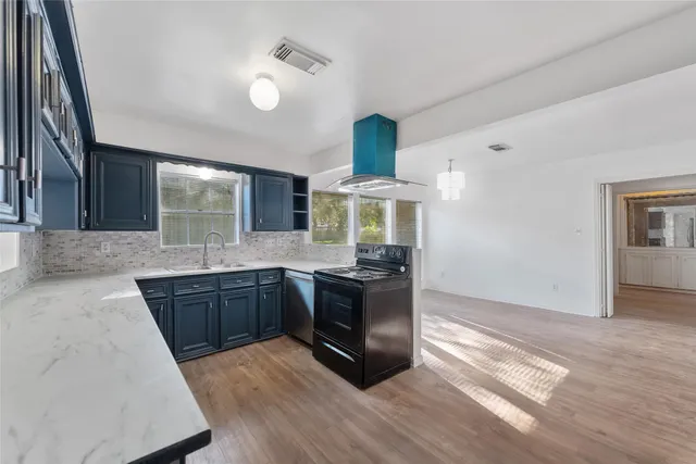 a kitchen with stainless steel appliances granite countertop a refrigerator and a stove top oven