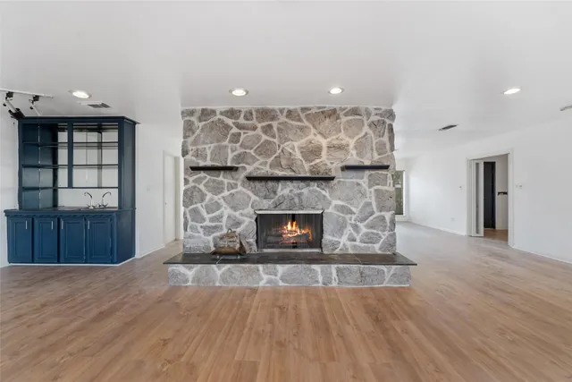 a view of empty room with wooden floor and fireplace