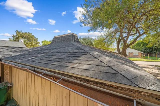 a view of an entryway with lots of frames on wall and wooden floor