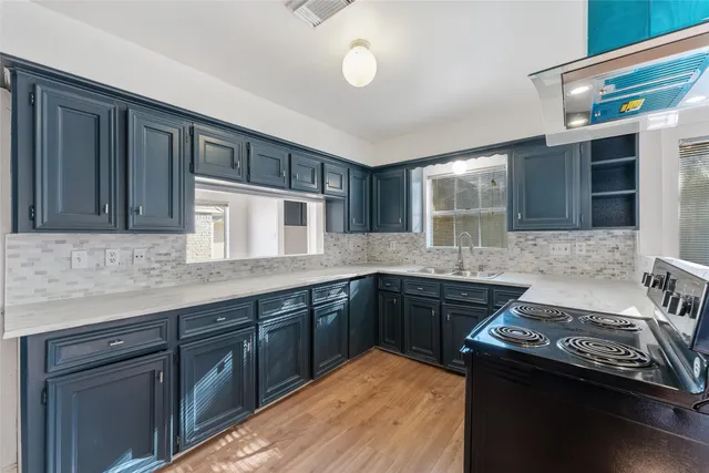 a kitchen with stainless steel appliances granite countertop a stove a sink and a refrigerator