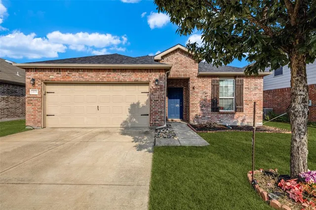 a front view of a house with a garden and yard