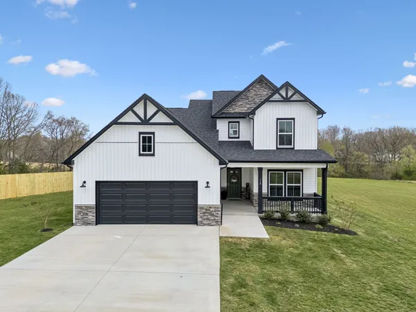 a kitchen with stainless steel appliances kitchen island granite countertop a refrigerator a stove a sink a dining table and chairs with wooden floor