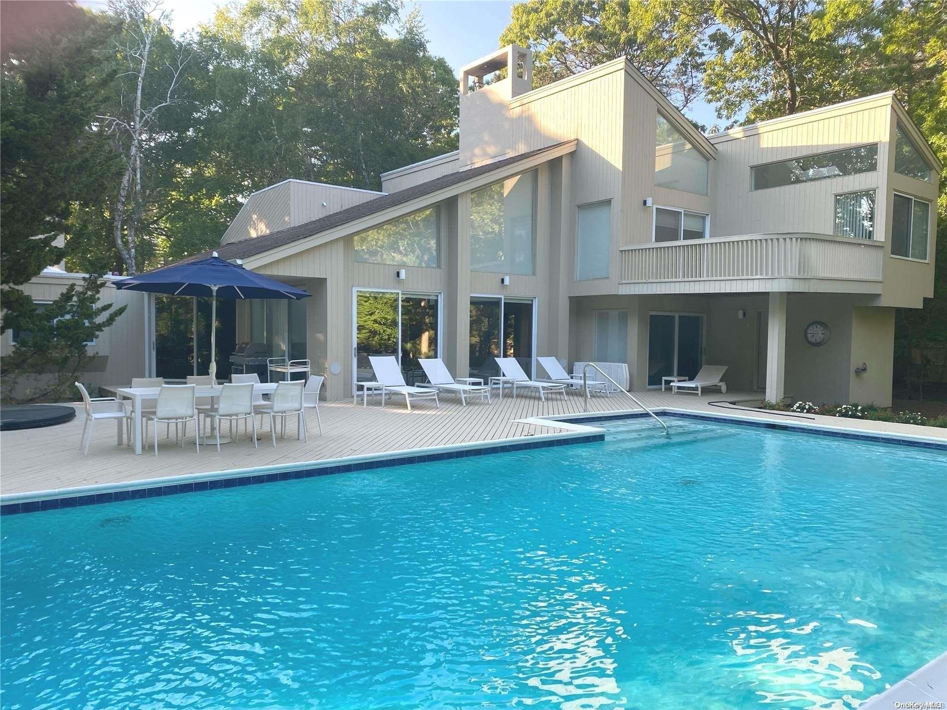 a view of house with swimming pool and chairs