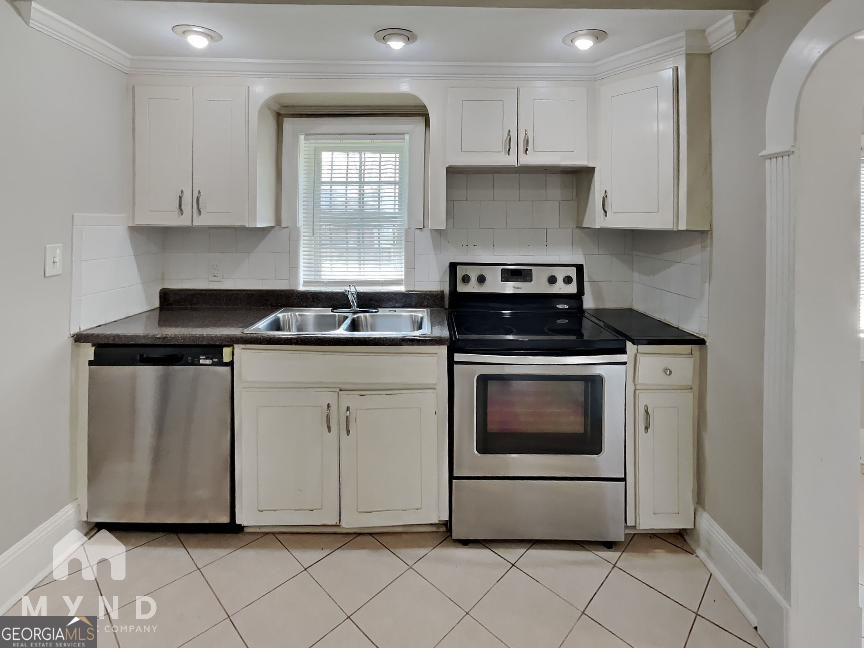 1337 South Hairston Road Stone Mountain, GA 30088 - Photo 2 of 17 a kitchen with white cabinets and appliances