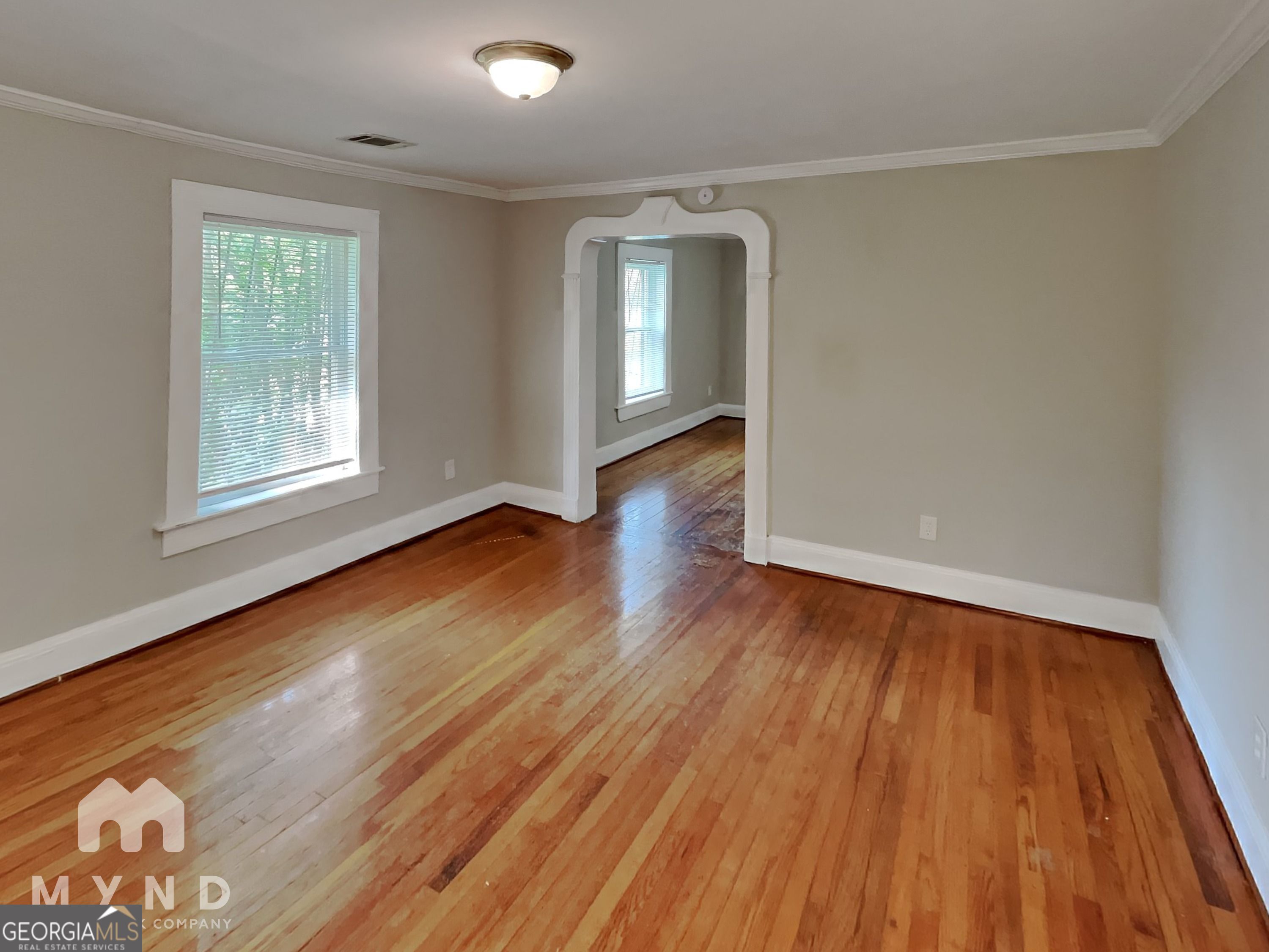 1337 South Hairston Road Stone Mountain, GA 30088 - Photo 5 of 17 an empty room with wooden floor and windows