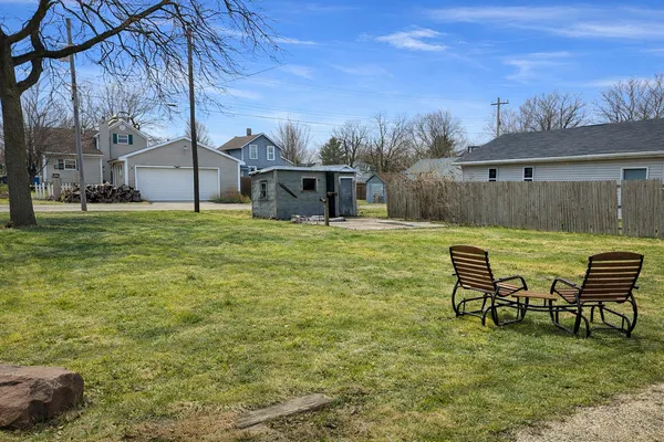 a backyard of a house with table and chairs