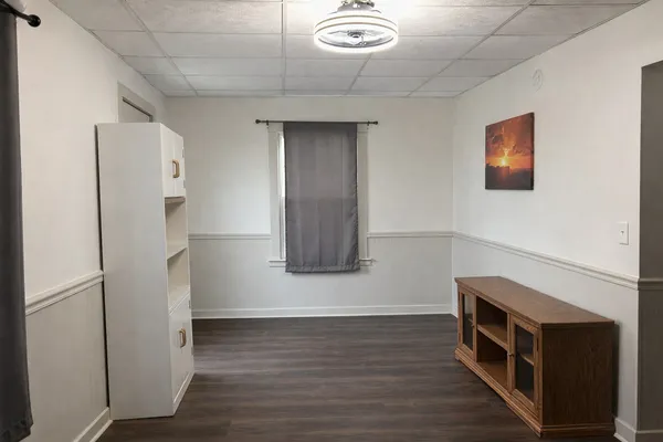 a hallway with wooden floor and cabinet