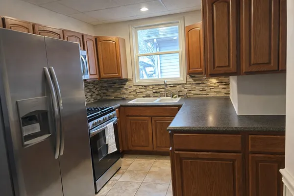 a kitchen with stainless steel appliances granite countertop a refrigerator and a sink