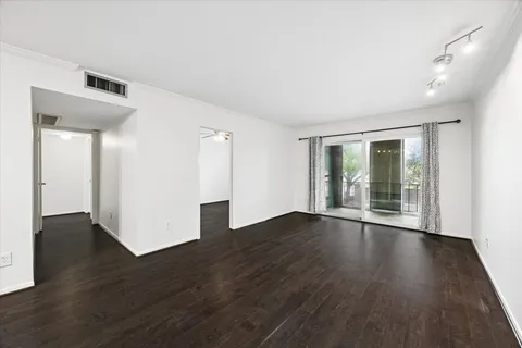 a view of an empty room with wooden floor