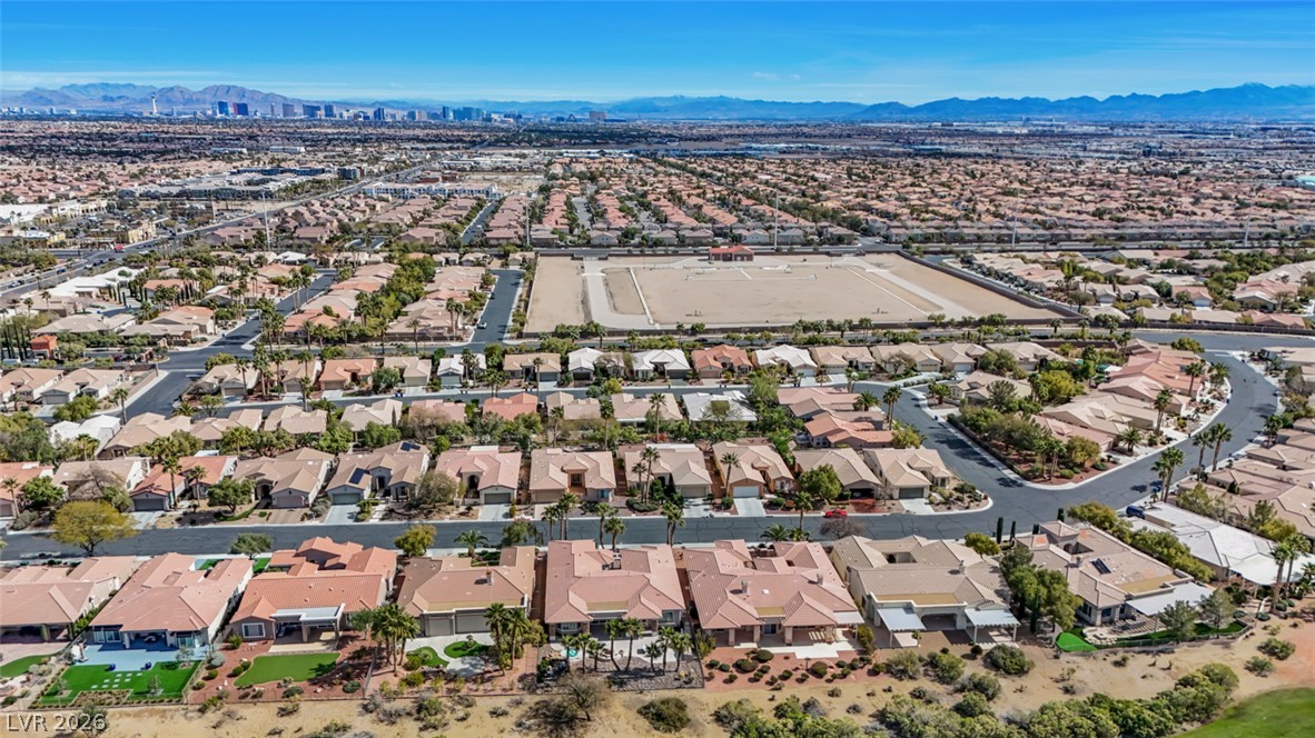 5015 Rivedro Street Las Vegas, NV 89135 - Photo 75 of 91 An aerial perspective reveals a vast residential community with a distant city skyline and rugged mountain backdrop.