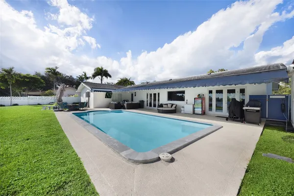 a view of a backyard with plants and palm tree
