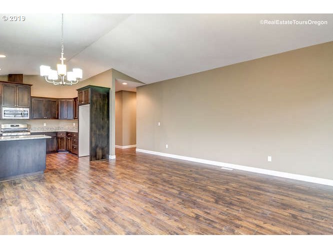 1060 6th Street Gervais, OR 97026 - Photo 14 of 30 a view of a kitchen with a sink wooden cabinets and chandelier