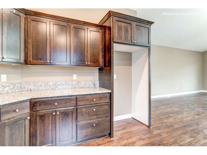 1060 6th Street Gervais, OR 97026 - Photo 17 of 30 a view of kitchen with granite countertop wooden cabinets and stainless steel appliances