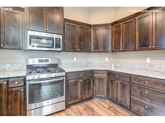 1060 6th Street Gervais, OR 97026 - Photo 19 of 30 a kitchen with granite countertop a stove and a sink