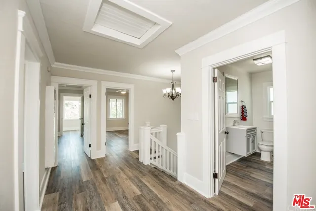 a kitchen that has a lot of white cabinets and wooden floor