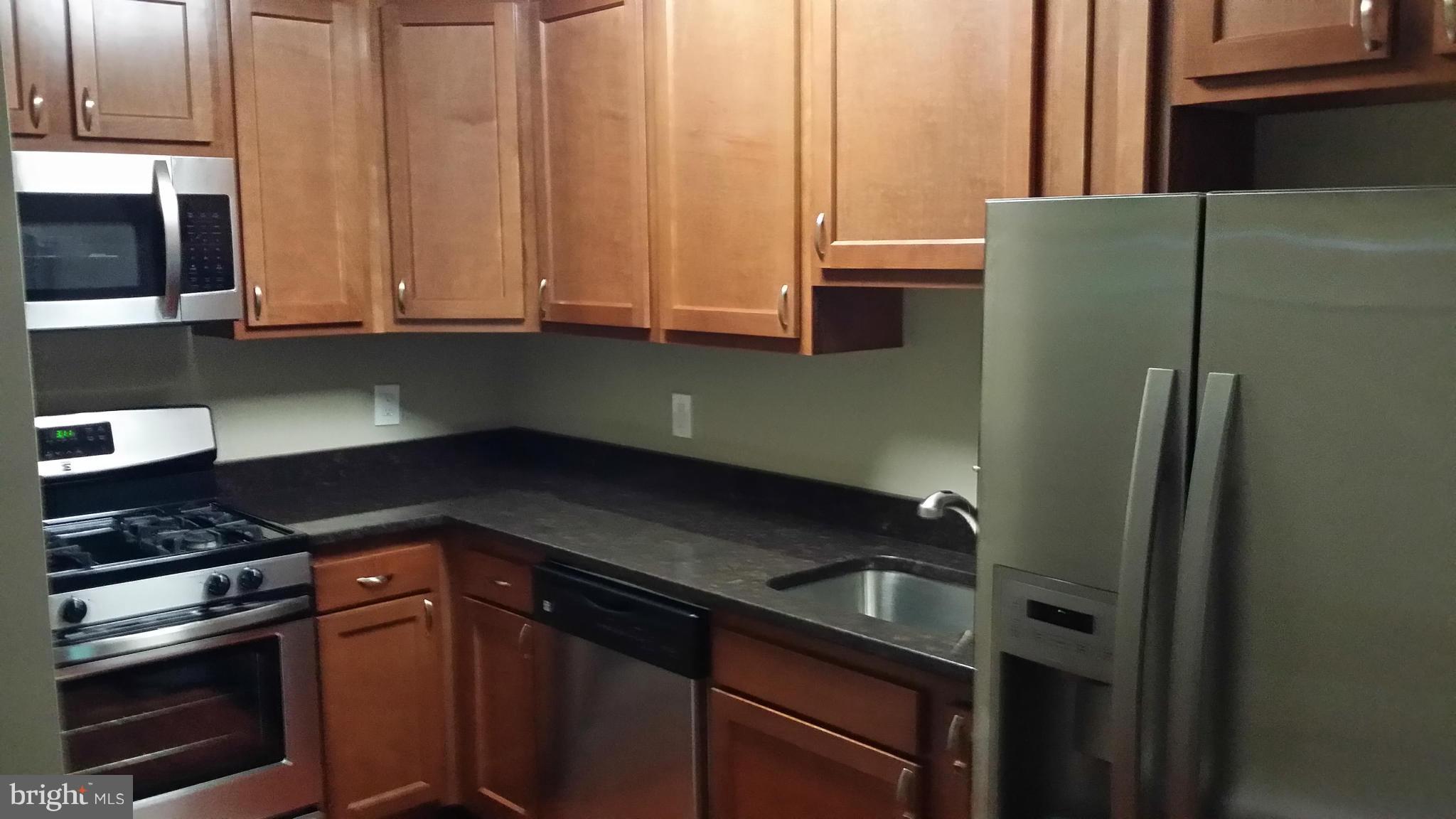 7634 Muncy Road Hyattsville, MD 20785 - Photo 3 of 21 a kitchen with stainless steel appliances granite countertop a refrigerator and a sink