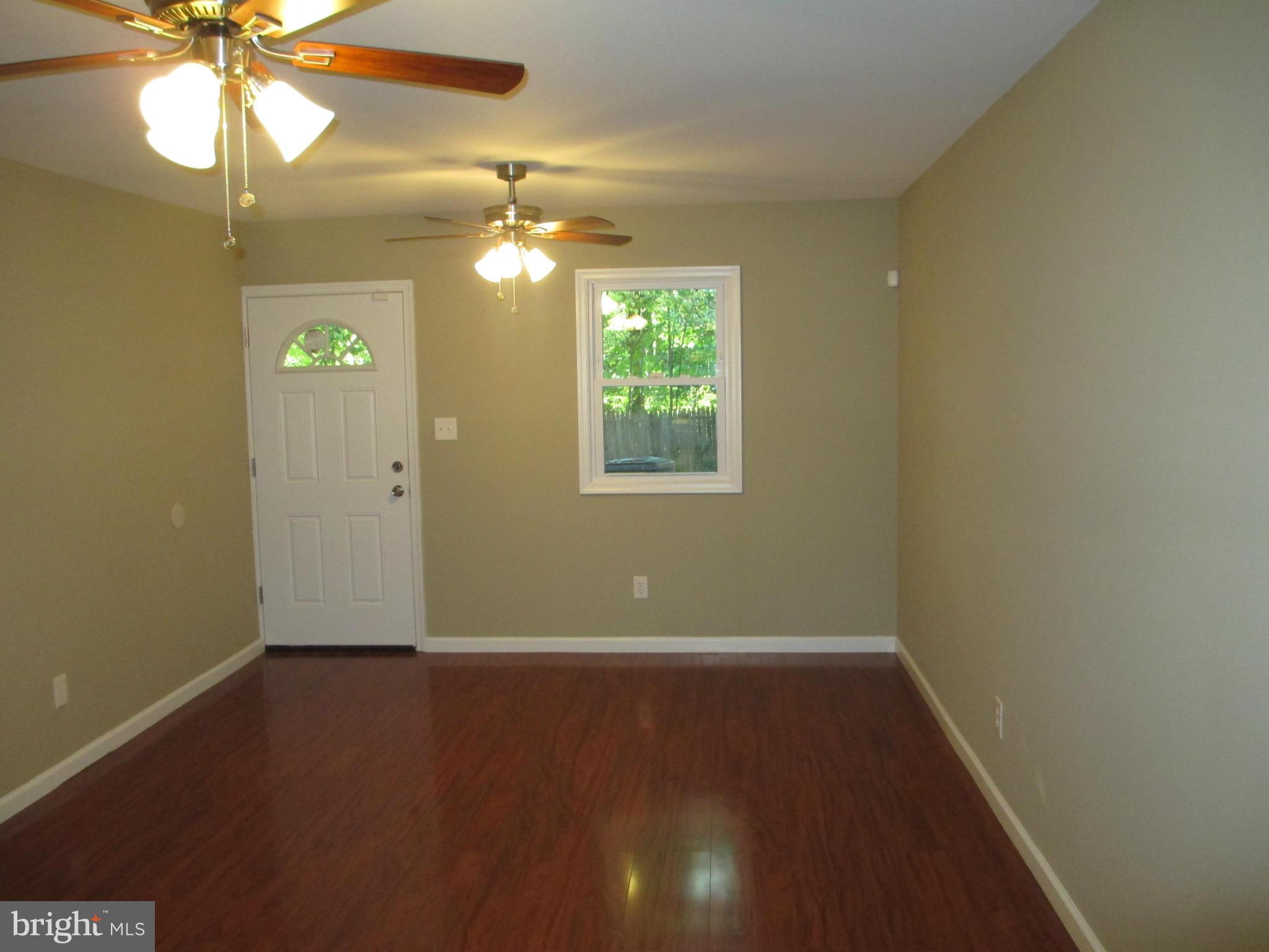7634 Muncy Road Hyattsville, MD 20785 - Photo 8 of 21 wooden floor in an empty room with a window