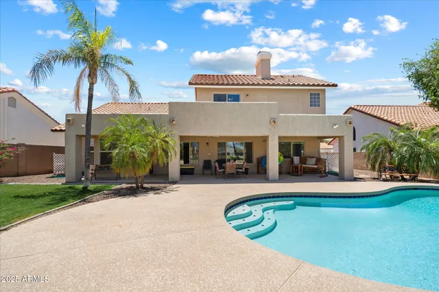 a view of a house with swimming pool and a yard