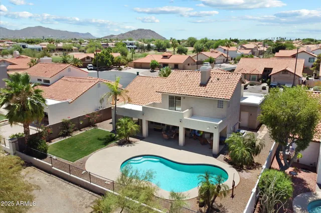 an aerial view of residential houses with outdoor space and parking