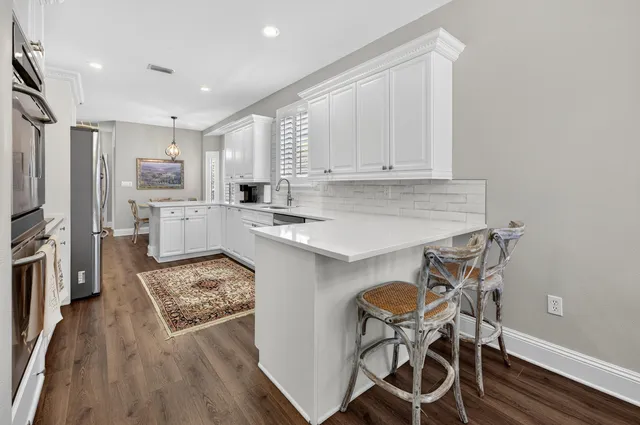 a kitchen with stainless steel appliances granite countertop a sink and dishwasher with white cabinets