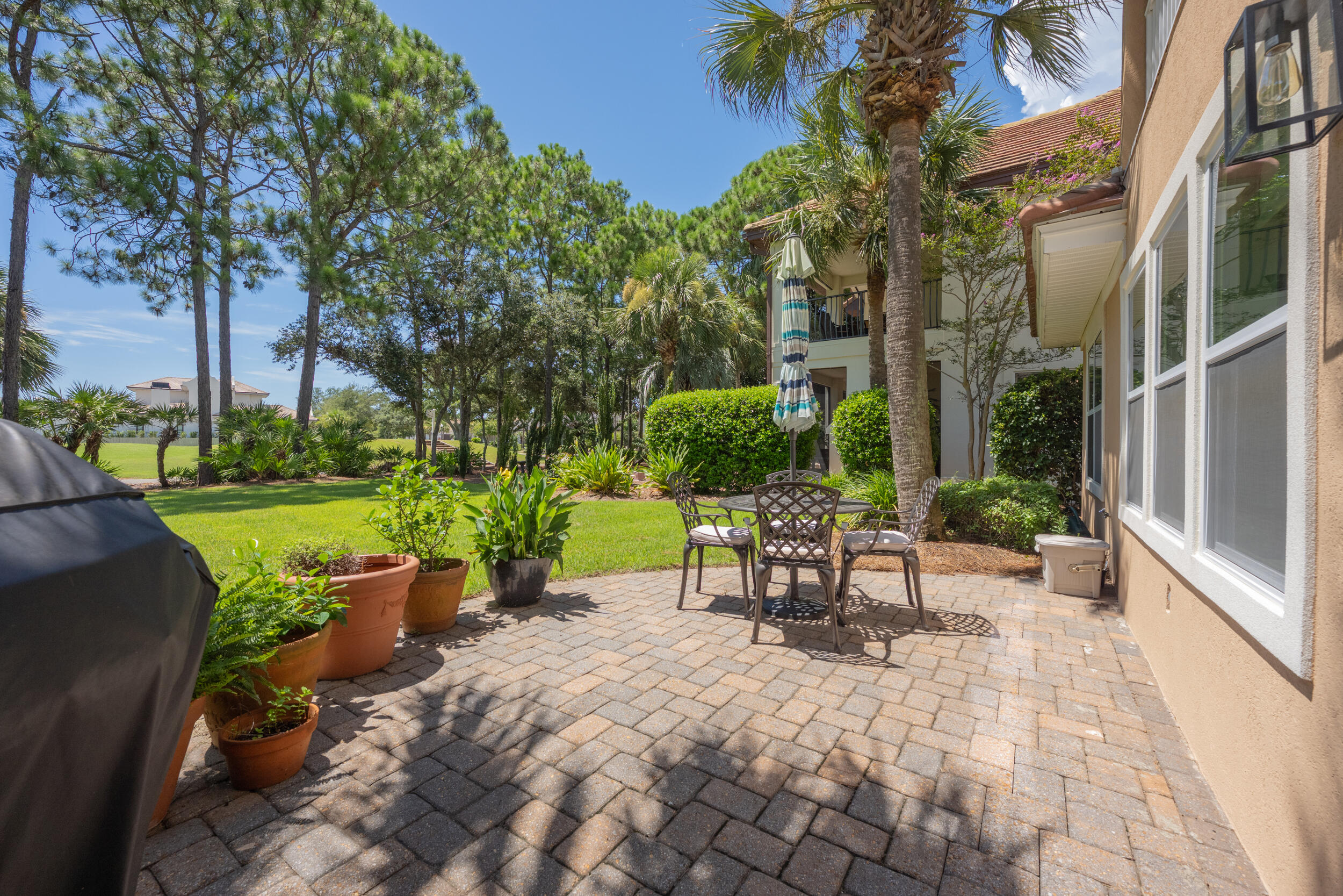 298 Ketch Court Destin, FL 32541 - Photo 59 of 79 a view of a patio with table and chairs potted plants and a large tree