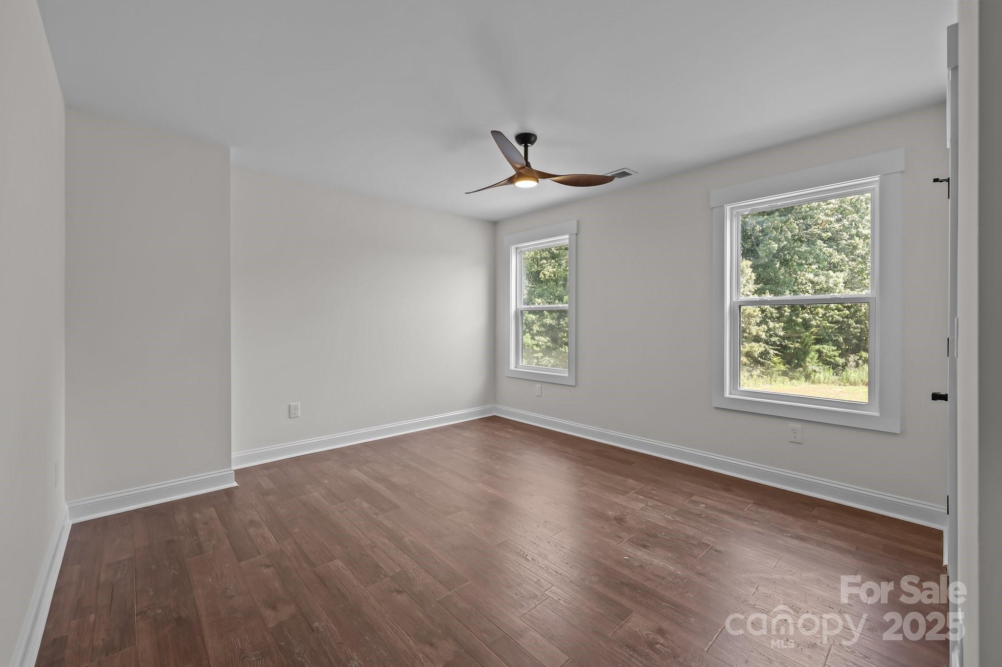 4040 Daugherty Road China Grove, NC 28023 - Photo 40 of 45 an empty room with wooden floor chandelier fan and windows