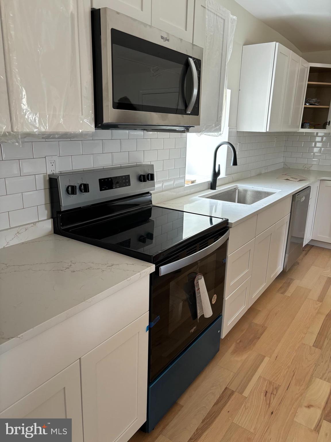 7501 Church Hill Road, Unit 5 Chestertown, MD 21620 - Photo 5 of 17 a kitchen with stainless steel appliances a stove a microwave a sink and cabinets