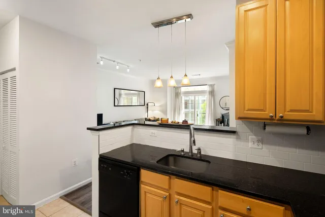 a kitchen with stainless steel appliances granite countertop a refrigerator and a couch