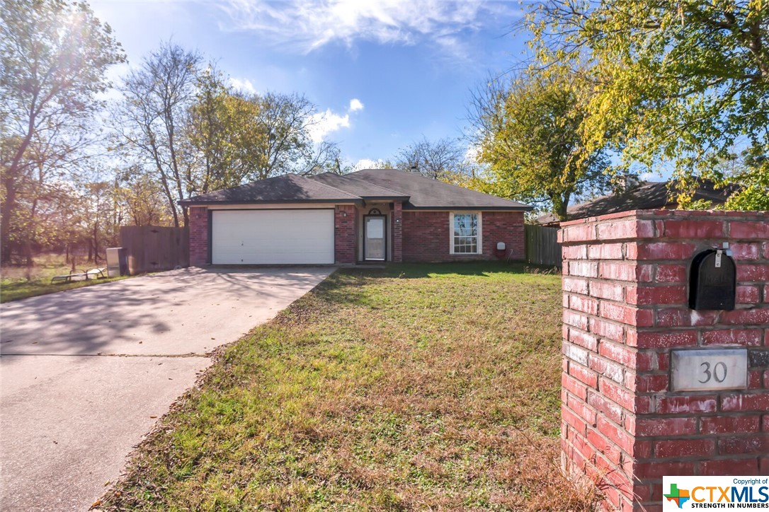 a front view of a house with a yard and large trees