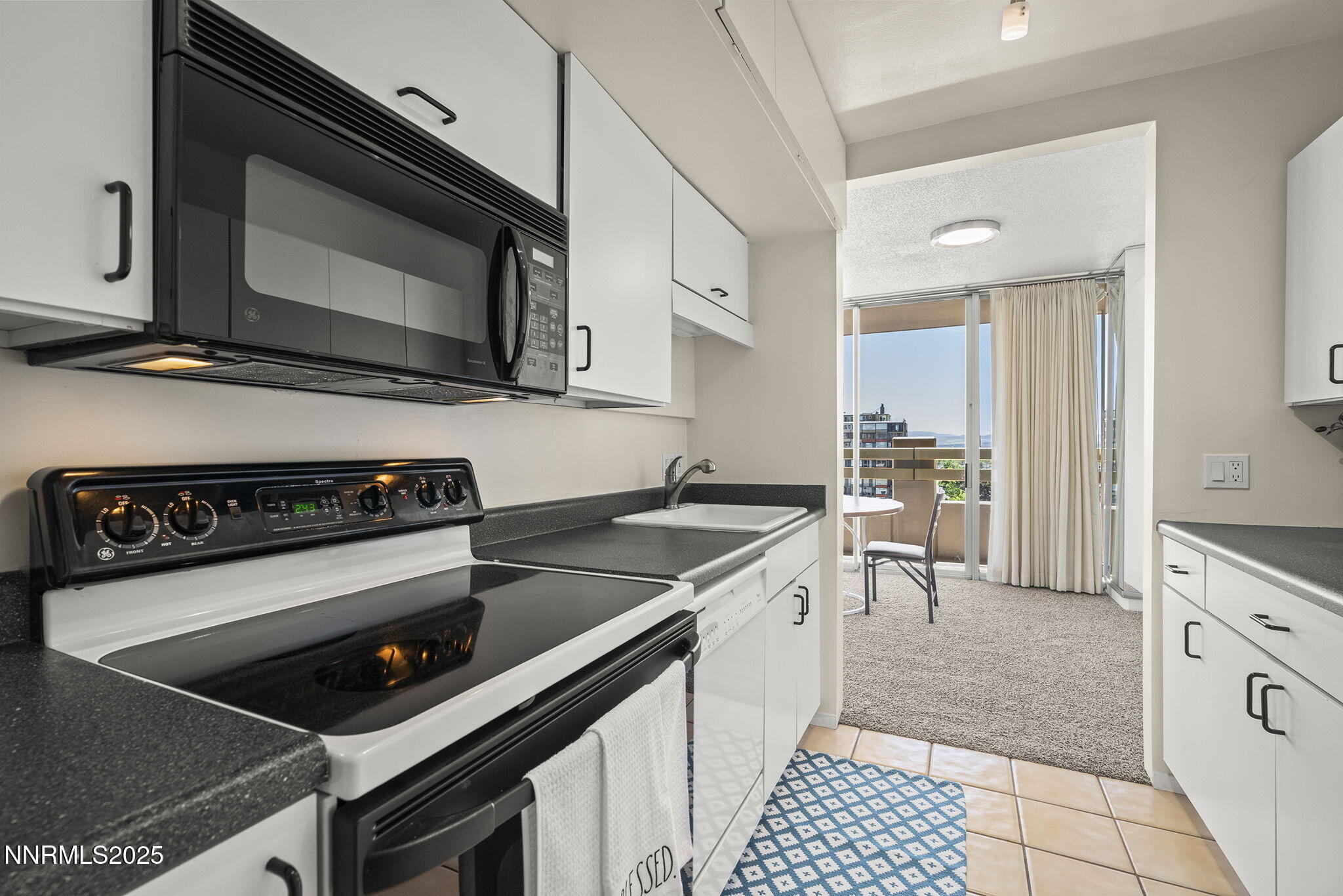 100 North Arlington Avenue, Unit 10E Reno, NV 89501 - Photo 11 of 47 a kitchen with a stove and a microwave