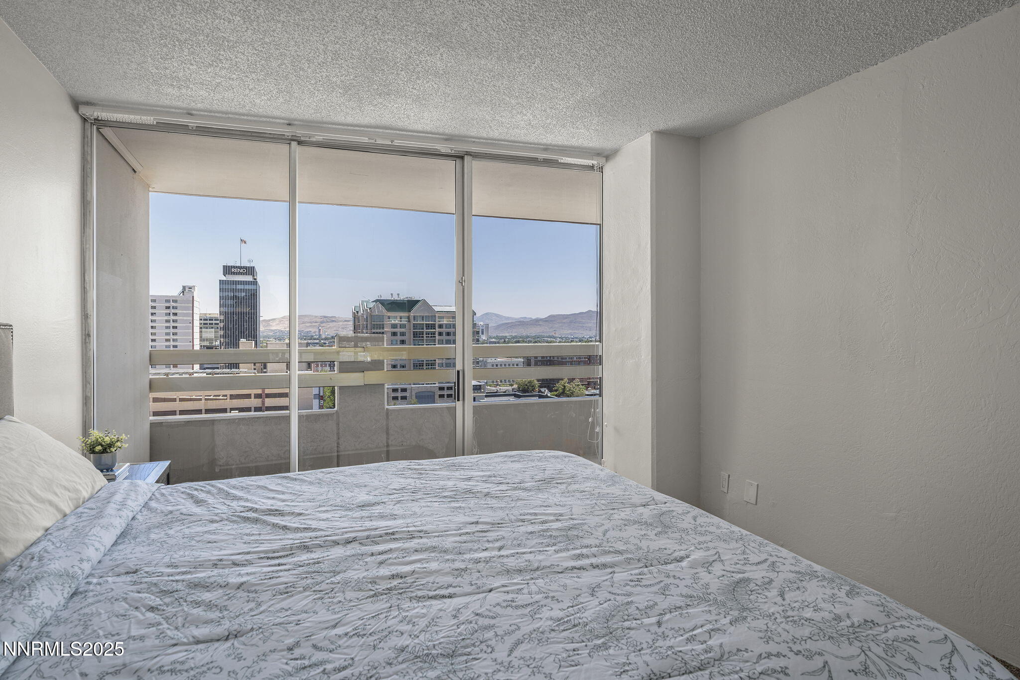 100 North Arlington Avenue, Unit 10E Reno, NV 89501 - Photo 13 of 47 a bedroom with a bed and a window