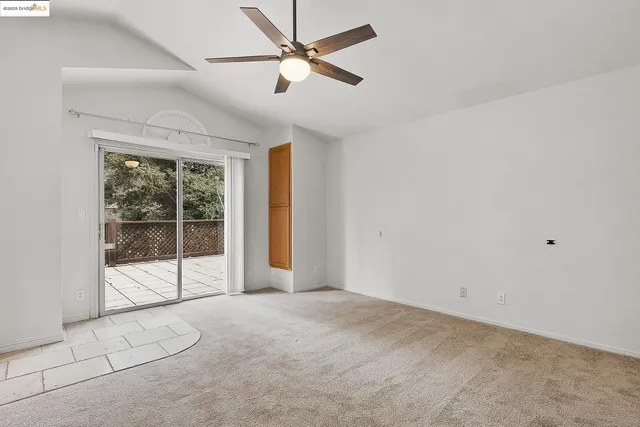 en empty room with a ceiling fan and a shower