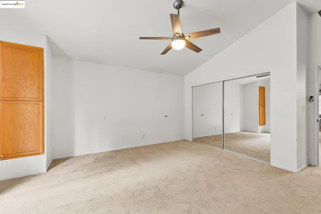 a view of a room with an empty space and a ceiling fan