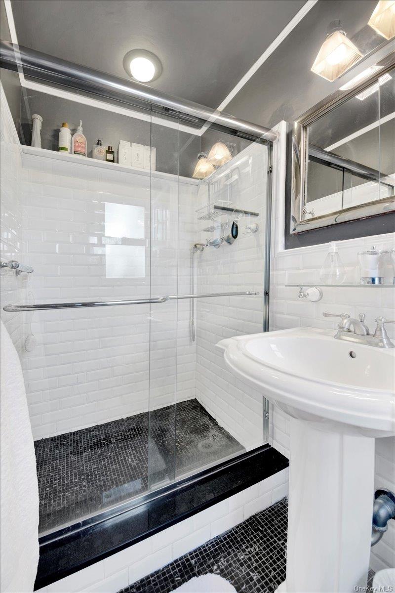 266 Pelham Road, Unit 5H New Rochelle, NY 10805 - Photo 14 of 27 a bathroom with a sink a toilet and a shower